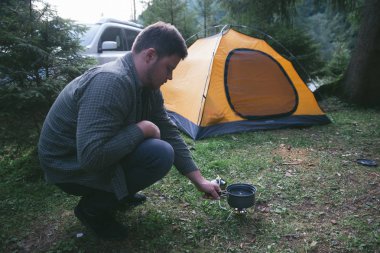 adam arka plan üzerinde kamp yangın çadır, yemek. Hiking kavramı