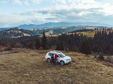 havadan görünümü çift beyaz jip araba Dağları ile orman ve arka plan bulutlu alanların yakınındaki