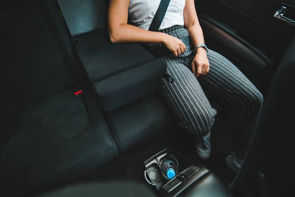 woman at backseats in car. road trip. bottle in cup holder