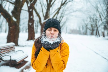 kadın onun elinden bulutlu. park arka plan üzerinde kar yağdı. Kış sezon kavramı