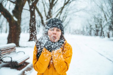 kadın onun elinden bulutlu. park arka plan üzerinde kar yağdı. Kış sezon kavramı