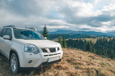 Beyaz jip araba arka plan hill dağlardaki en üstündeki hava bulutlu
