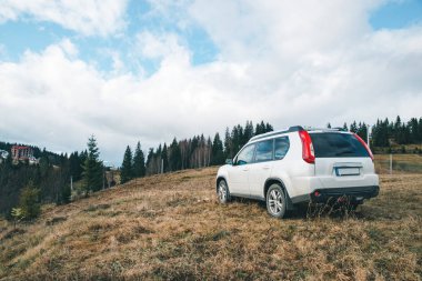 Beyaz jip araba arka plan hill dağlardaki en üstündeki hava bulutlu