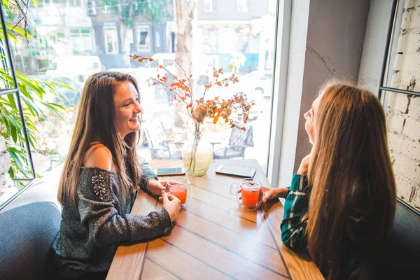 两个女朋友一边喝茶一边在咖啡馆里聊天 会议理念 — 图库照片