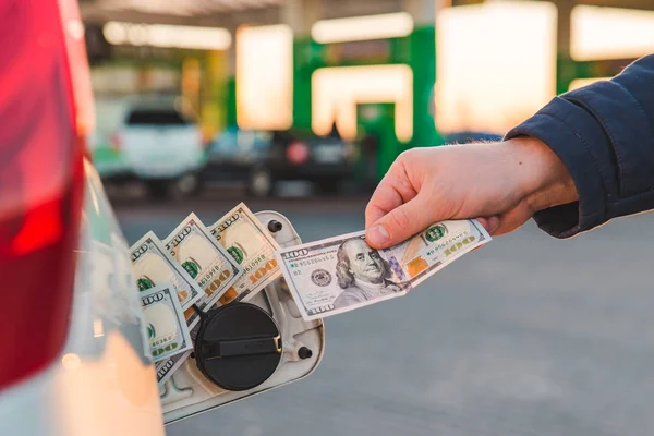 男の手は 車の燃料タンクにお金を置きます 給油車 ガソリン スタンドの概念 — ストック写真
