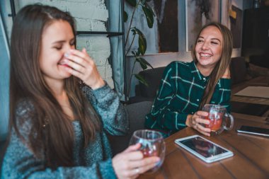 iki kız arkadaşım kafede içki ise bir çay konuşuyor. Toplantı kavramı