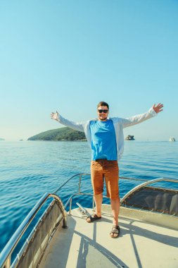 burun arka plan üzerinde deniz ve dağlar ile teknenin, ayakta başarı adam. yaz tatili