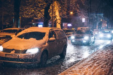yol şehir trafiğinde kış kar fırtınası gece. Daralt