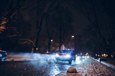 yol şehir trafiğinde kış kar fırtınası gece. Daralt