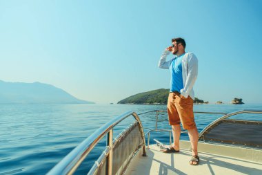 burun arka plan üzerinde deniz ve dağlar ile teknenin, ayakta başarı adam. yaz tatili