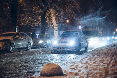 yol şehir trafiğinde kış kar fırtınası gece. Daralt