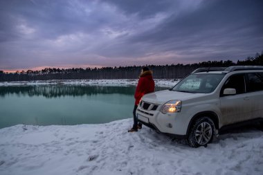 adamın yanına suv araba kış zaman. arka plan üzerinde Ormanla göl. aktif yaşam tarzı