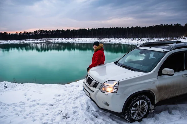 adamın yanına suv araba kış zaman. arka plan üzerinde Ormanla göl. aktif yaşam tarzı
