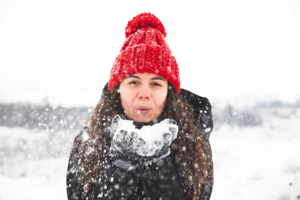 Kvinna i röd mössa med bubo hålla snö i händer Stockbild