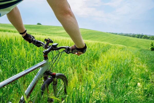 緑のフィールドで強力な若者乗馬自転車 — ストック写真