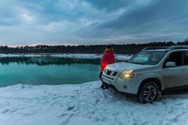 adamın yanına suv araba kış zaman. arka plan üzerinde Ormanla göl. aktif yaşam tarzı