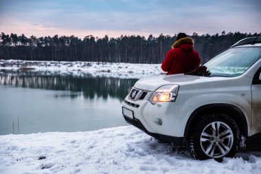 Kış göl manzarasına zevk suv arabanın yakınında ayakta adam. seyahat kavramı