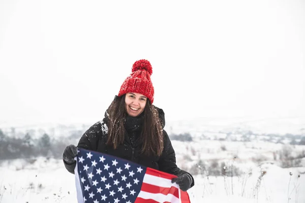 Ung Smilende Kvinne Med Rød Hatt Som Holder Flagg Vinterstid – stockfoto