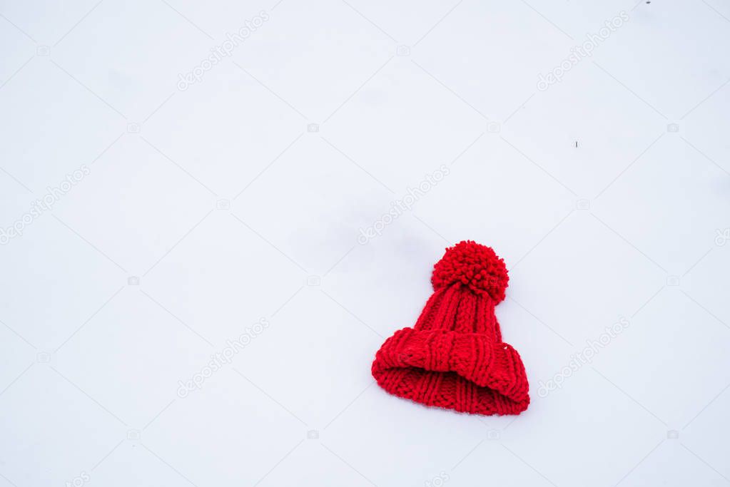 red hat with bubo on white snow. overhead view. flat lay