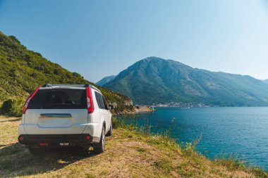 Beyaz jip araba Bay Dağları ile güzel manzaralı sahil Park. araba yolculuğu