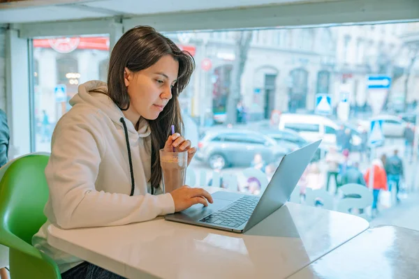 年轻漂亮的女人坐在咖啡馆里 带着笔记本电脑 喝着热巧克力 办公室工作 — 图库照片