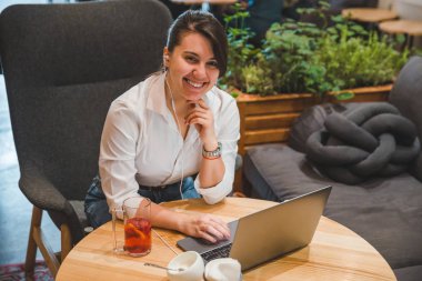 laptop ve meyve çay dinleme müzik kulaklık kadınla kafede. Freelancer kavramı