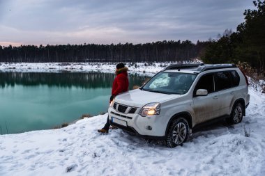 adamın yanına suv araba kış zaman. arka plan üzerinde Ormanla göl. aktif yaşam tarzı