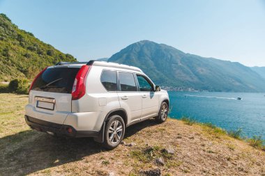 Beyaz jip araba Bay Dağları ile güzel manzaralı sahil Park. araba yolculuğu