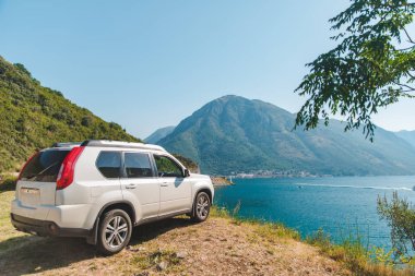 Beyaz jip araba Bay Dağları ile güzel manzaralı sahil Park. araba yolculuğu