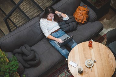 çay içme dizüstü kullanarak kafede oturan kadın. beyaz ekran. kopya alanı. yaşam tarzı