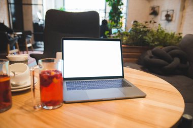 Laptop beyaz ekran ile kafede masada. kopya alanı
