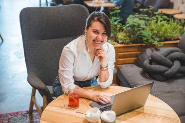 laptop ve meyve çay dinleme müzik kulaklık kadınla kafede. Freelancer kavramı