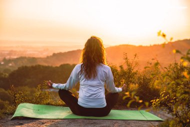 kadın yapma egzersiz gündoğumu üstünde belgili tanımlık tepe üzerinde. sağlıklı yaşam tarzı.
