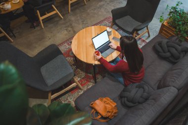 çay içme dizüstü kullanarak kafede oturan kadın. beyaz ekran. kopya alanı. yaşam tarzı