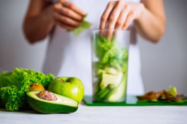 Smoothie maddeler önünde. arka plan üzerinde yapım güler yüzlü kadın. sağlık gıda kavramı