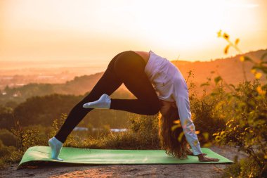 kadın yapma egzersiz gündoğumu üstünde belgili tanımlık tepe üzerinde. sağlıklı yaşam tarzı.