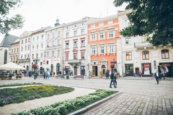 LVIV, UKRAINE - June 23, 2018: tourists walking with umbrella in the center of lviv city. tourism concept