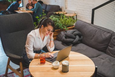 laptop ve meyve çay dinleme müzik kulaklık kadınla kafede. Freelancer kavramı
