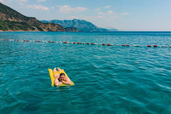 Jonge Volwassen Man Gele Opblaasbare Matras Blauwe Zee Zwemmen Bergen — Stockfoto