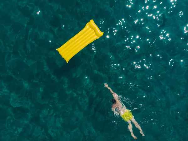 Homem Adulto Jovem Nadando Colchão Inflável Amarelo Mar Azul Montanhas — Fotografia de Stock