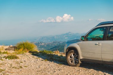 dağlar arka plan üzerinde beyaz jip araba tepe tepenin üzerinde. araba seyahat