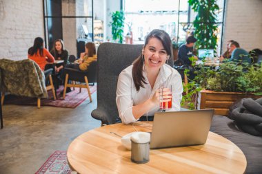 laptop ve meyve çay dinleme müzik kulaklık kadınla kafede. Freelancer kavramı