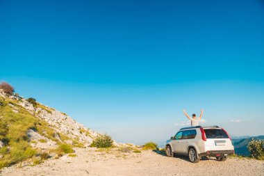 adam yakınındaki tepenin en yüksek dağların güzel manzaralı beyaz jip araba ayakta