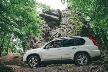 ormanda SUV arabayı kullanan adam. yoldan çekilin. yaşam tarzı kavramı