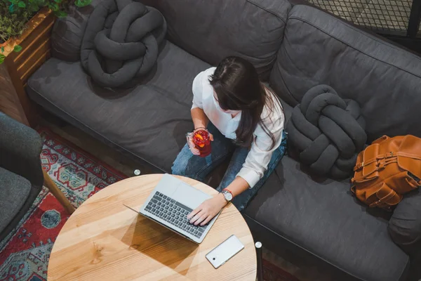 çay içme dizüstü kullanarak kafede oturan kadın. beyaz ekran. kopya alanı. yaşam tarzı