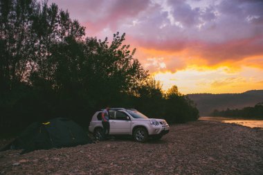 Rivershore sunrise kamp. Beyaz jip araba. yaşam tarzı