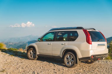 dağlar arka plan üzerinde beyaz jip araba tepe tepenin üzerinde. araba seyahat