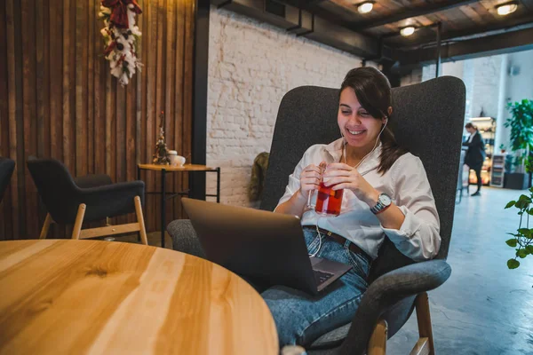Woman Sitting Big Chair Cafe Laptop Listening Music Headset Drinking — Stock Photo, Image