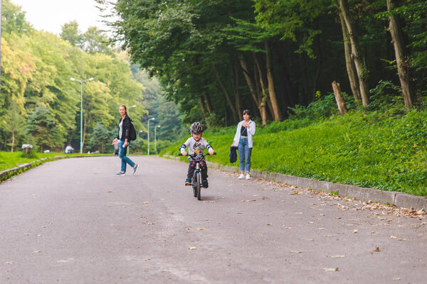 LVIV, UKRAINE - August 18, 2018: little boy riding bicycle in helmet