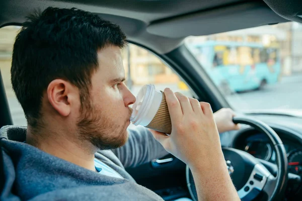 Muž řídil auto a pití kávy — Stock fotografie